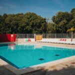 Piscine extérieure avec chaises longues au Camping le Rancho