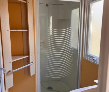 Salle d'eau avec cabine de douche et lavabo au Camping le Rancho