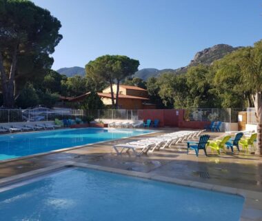 Piscine extérieure et transats avec montagnes en arrière-plan au Camping le Rancho