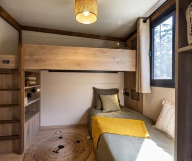Coin nuit avec lits superposés et fenêtre au Camping le Relais du Léman