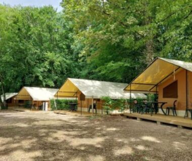 Tentes lodge sur plateforme sous les arbres au Camping le Rivage