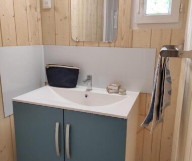 Salle de bain avec lavabo et miroir au Camping le Rouge Gorge
