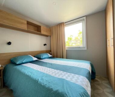Chambre avec lits jumeaux et fenêtre dans le mobil-home L’ABRIZEN 254
