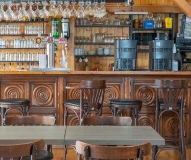 Bar intérieur avec comptoir en bois et tabourets au Camping les 3 Sablières