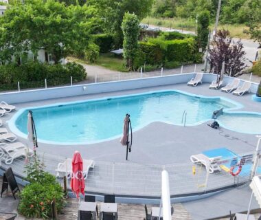 Piscine extérieure avec solarium et chaises longues au Camping les 3 Sablières