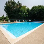 Piscine extérieure avec transats au Camping les Avenières