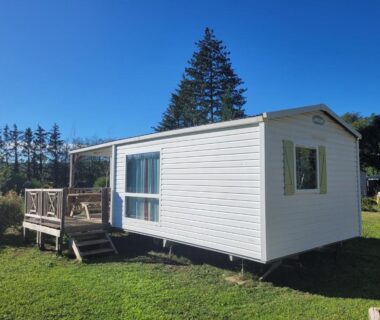 Mobil-home blanc avec terrasse sur la pelouse au Camping les Avenières