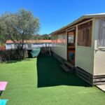Espace extérieur avec pelouse et transats devant mobil home au Camping les Cigales Tikayan