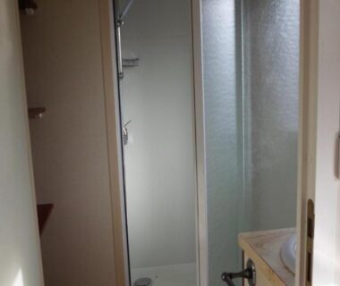 Salle de bains avec cabine de douche et lavabo dans le Camping les Pinasses