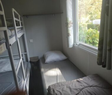 Chambre avec lits superposés et fenêtre du Camping les Sables