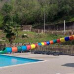 Piscine extérieure avec toboggan coloré au Camping les Sables