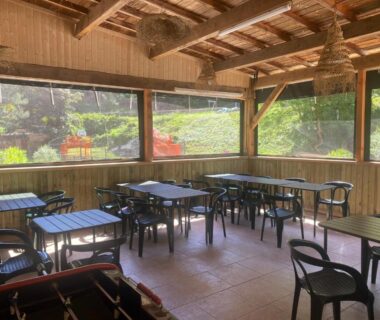 Terrasse couverte avec tables et chaises au Camping les Sables