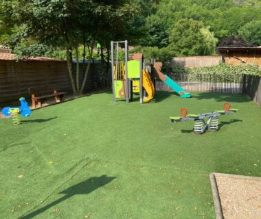 Aire de jeux avec toboggan balançoires et sol en gazon au Camping les Sables