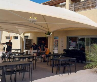 Terrasse extérieure couverte avec tables et chaises au Camping les Salins de la Gardiole