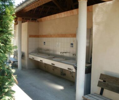 Espace vaisselle extérieur avec éviers sous abri au Camping les Silhols