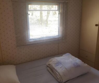 Chambre avec lit et fenêtre au Camping les Tourterelles Chalets et mobilhomes