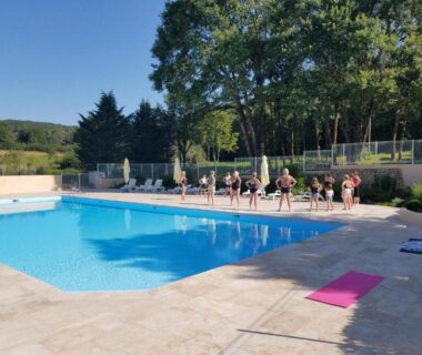Bord de la piscine avec transats et personnes au Camping les Tourterelles Chalets et mobilhomes