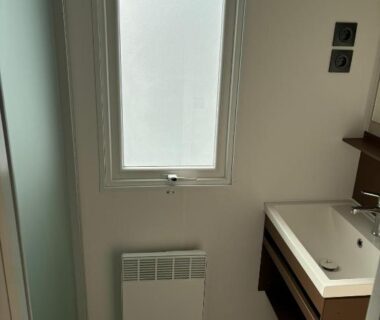 Salle de bain avec lavabo et fenêtre dans le Mobil Home du Camping les dunes 5 étoiles