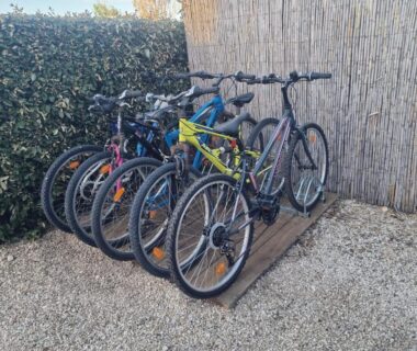 Vélos rangés sur gravier devant haie au Camping les dunes Torreilles Plages Bungalow M027 chez D&D