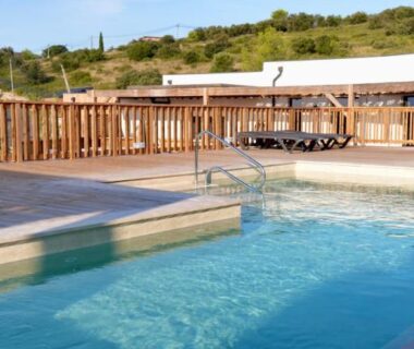 Piscine extérieure avec terrasse et transats au Camping les lodges du lagon