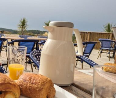 Terrasse avec croissants, jus et thermos au Camping les lodges du lagon