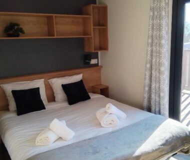 Chambre avec lit double et serviettes au Camping les lodges du lagon