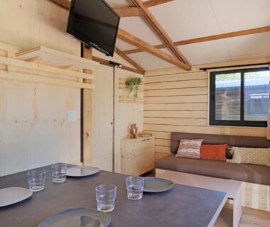 Intérieur avec coin repas et canapé du Camping les vergers de Squividan