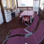 Terrasse couverte avec transats table et kitchenette au Camping l'escale