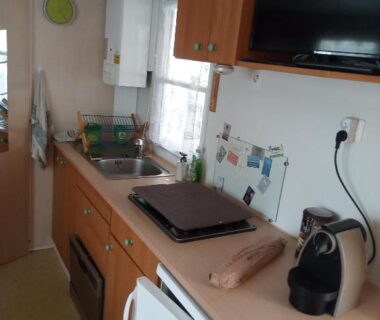 Cuisine équipée avec évier plaques et réfrigérateur dans le mobil-home Camping l'escale