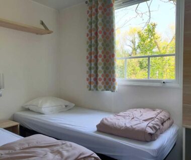 Chambre avec deux lits et fenêtre dans le camping l'île Cariot