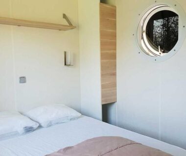 Chambre double avec hublot et lit soigné au Camping l'île Cariot