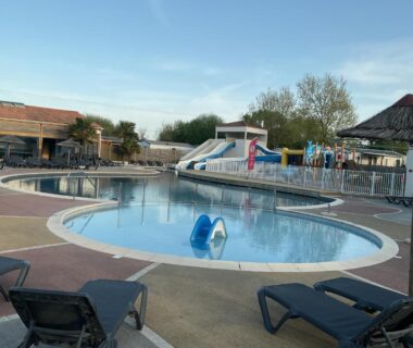 Piscine extérieure avec toboggan et transats au Camping loyoda