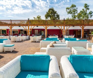 Terrasse lounge extérieure avec canapés blancs et coussins turquoises au Camping maeva Club Le Lagon d'Argelès