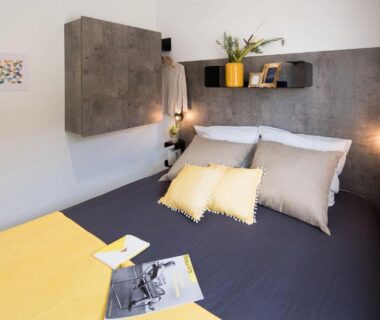 Chambre avec lit double coussins et rangements dans un mobil-home au Camping maeva Club Les Préveils