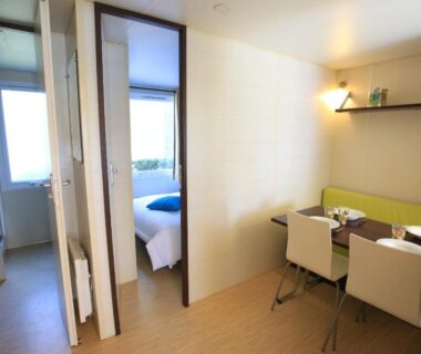 Intérieur de mobil-home avec coin repas et chambres au Camping maeva Club Les Préveils