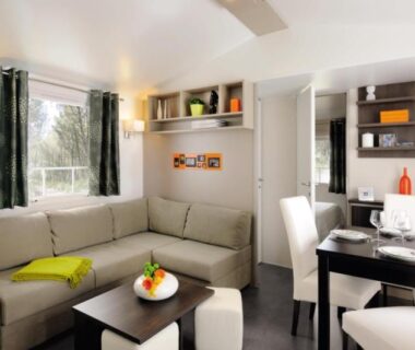 Séjour lumineux avec canapé et coin repas dans le camping maeva Club Les Préveils