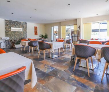 Salle de restaurant avec tables et chaises au Camping maeva Escapades Colomba