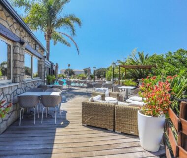 Terrasse en bois avec salon extérieur et piscine au Camping maeva Escapades Colomba