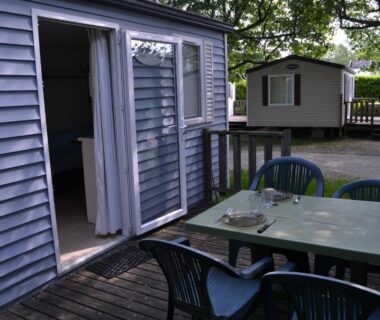 Terrasse en bois avec table et chaises au Camping maeva Escapades Le Casque Roi