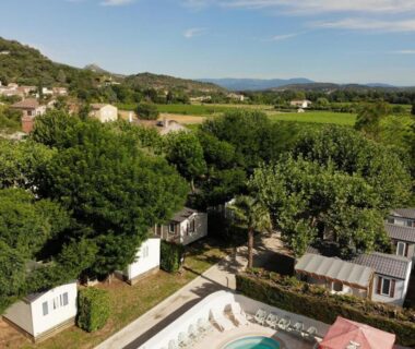 Piscine et mobil-homes au cœur des arbres au camping maeva Escapades Le Casque Roi