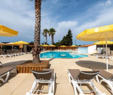 Espace piscine avec transats et parasols au Camping maeva Escapades Les Cottages de Perpignan
