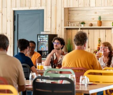 Salle commune avec convives et tables colorées au Camping maeva Escapades Les Cottages de Perpignan