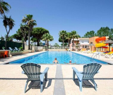 Piscine extérieure avec transats et toboggan au Camping maeva Escapades Les Jardins d'Agathe
