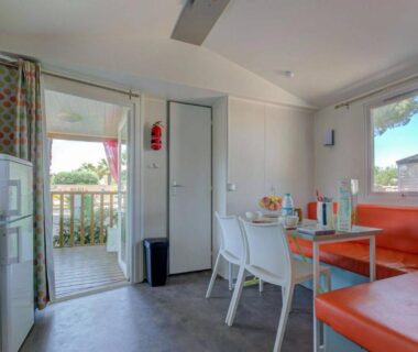 Terrasse et coin repas intérieur avec kitchenette et banquette du Camping maeva Escapades Les Jardins d'Agathe