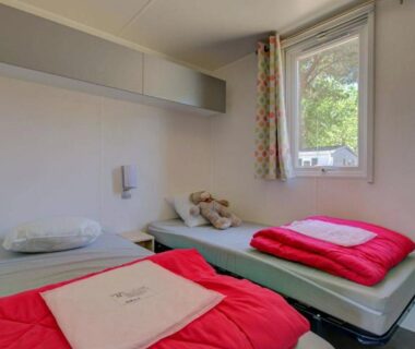 Chambre avec deux lits et peluche au Camping maeva Escapades Les Jardins d'Agathe