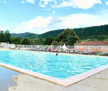 Piscine extérieure et terrasse avec vue sur les collines au camping maeva Escapades Ludo Parc