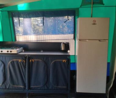 Intérieur de tente avec kitchenette et réfrigérateur au Camping maeva Escapades Ludo Parc