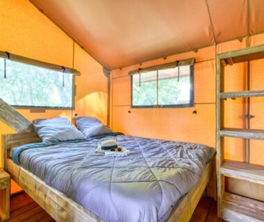 Intérieur de tente avec lit et étagères dans le camping maeva Escapades Millau Plage