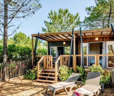 Terrasse en bois avec transats et pins dans le Camping maeva Respire Domaine de Sainte Montaine