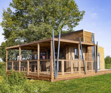 Terrasse en bois et véranda sur pelouse au Camping maeva Respire Domaine de Sainte Montaine
